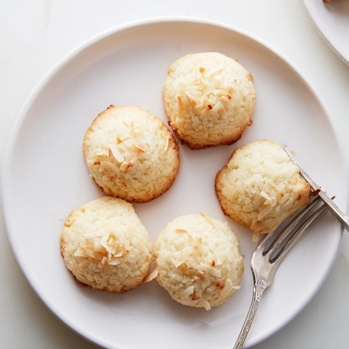Close-up of soft and buttery coconut cookies sprinkled with shredded coconut flakes