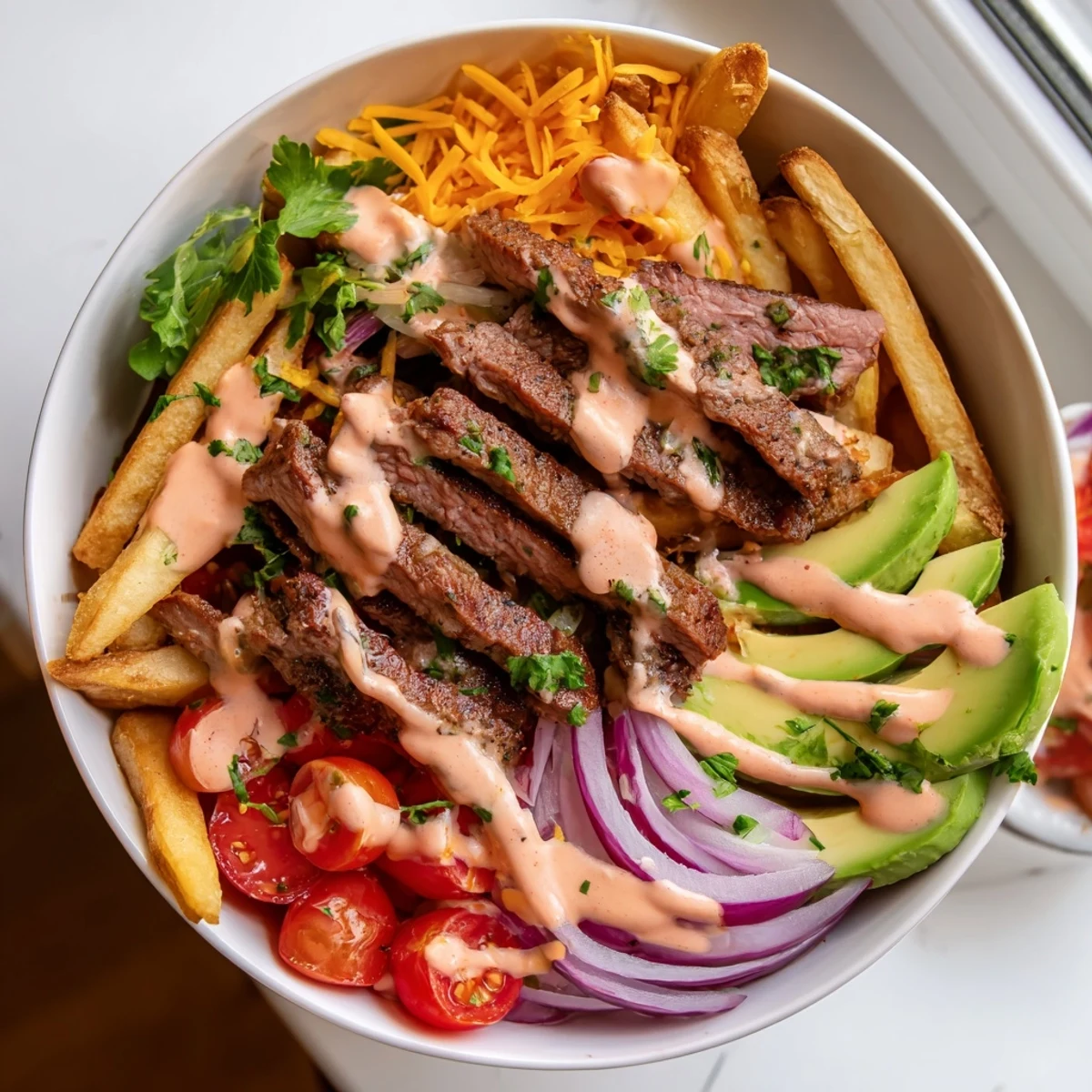Hearty steak strips crispy fries bowl loaded with fresh avocado, cherry tomatoes, and zesty mustard sauce