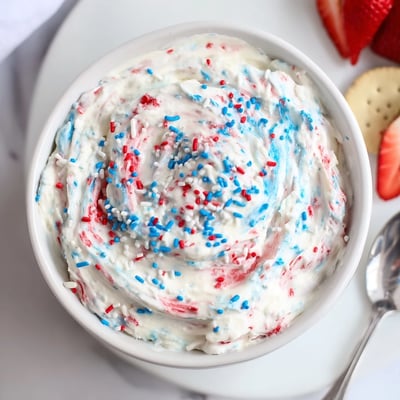 Chilled Red White And Blue Funfetti Dip served with vanilla wafers and strawberries.